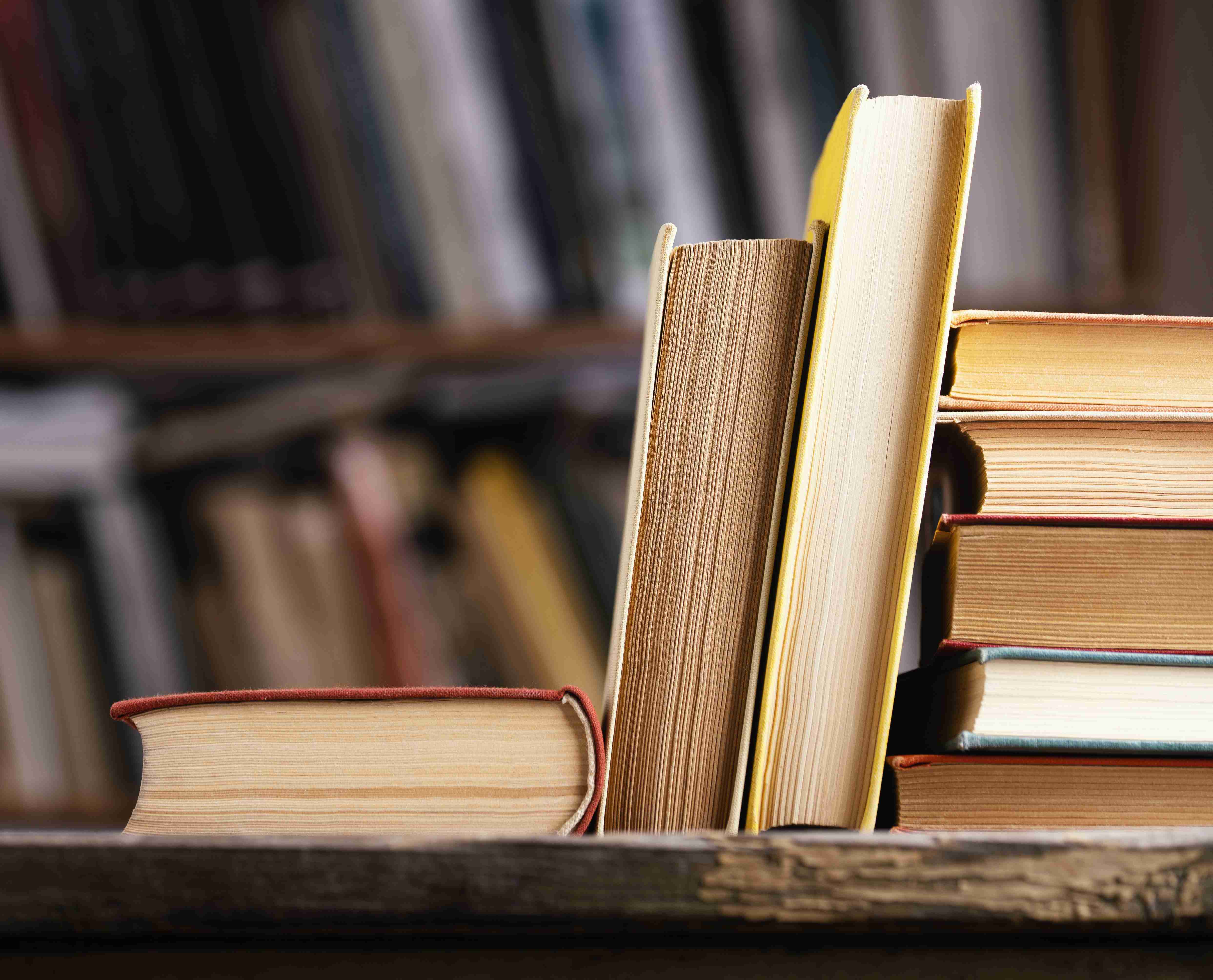 front view of hardback books in the library with copy space